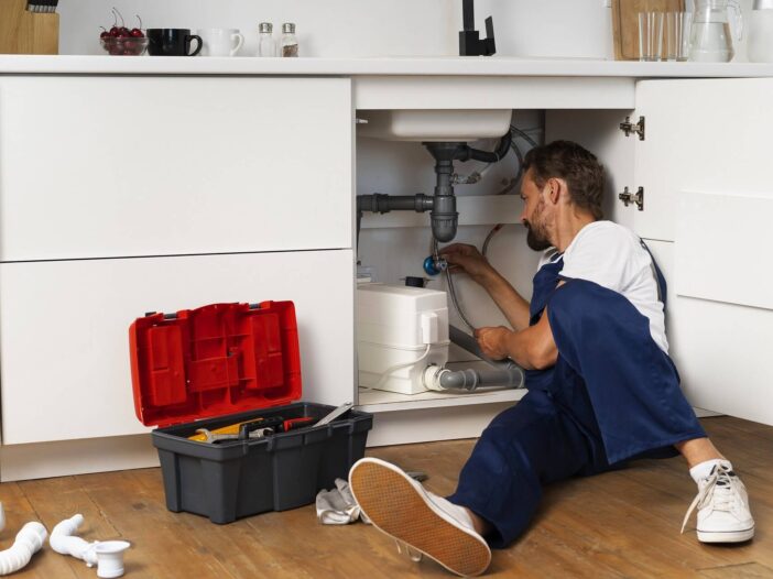 Rörmokare jobbar med avloppsrör