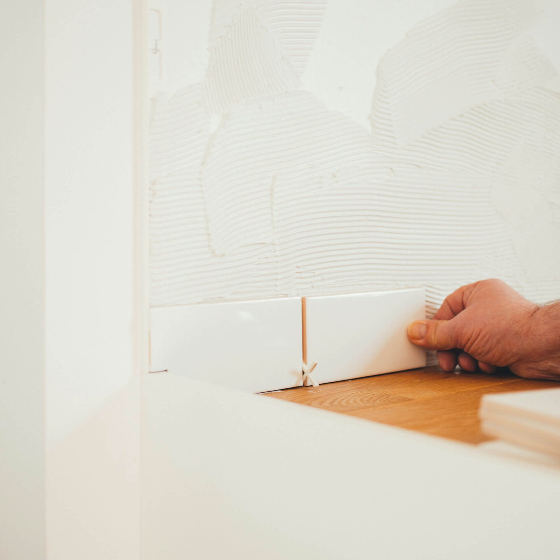 Plattsättare som sätter kakel i kök.