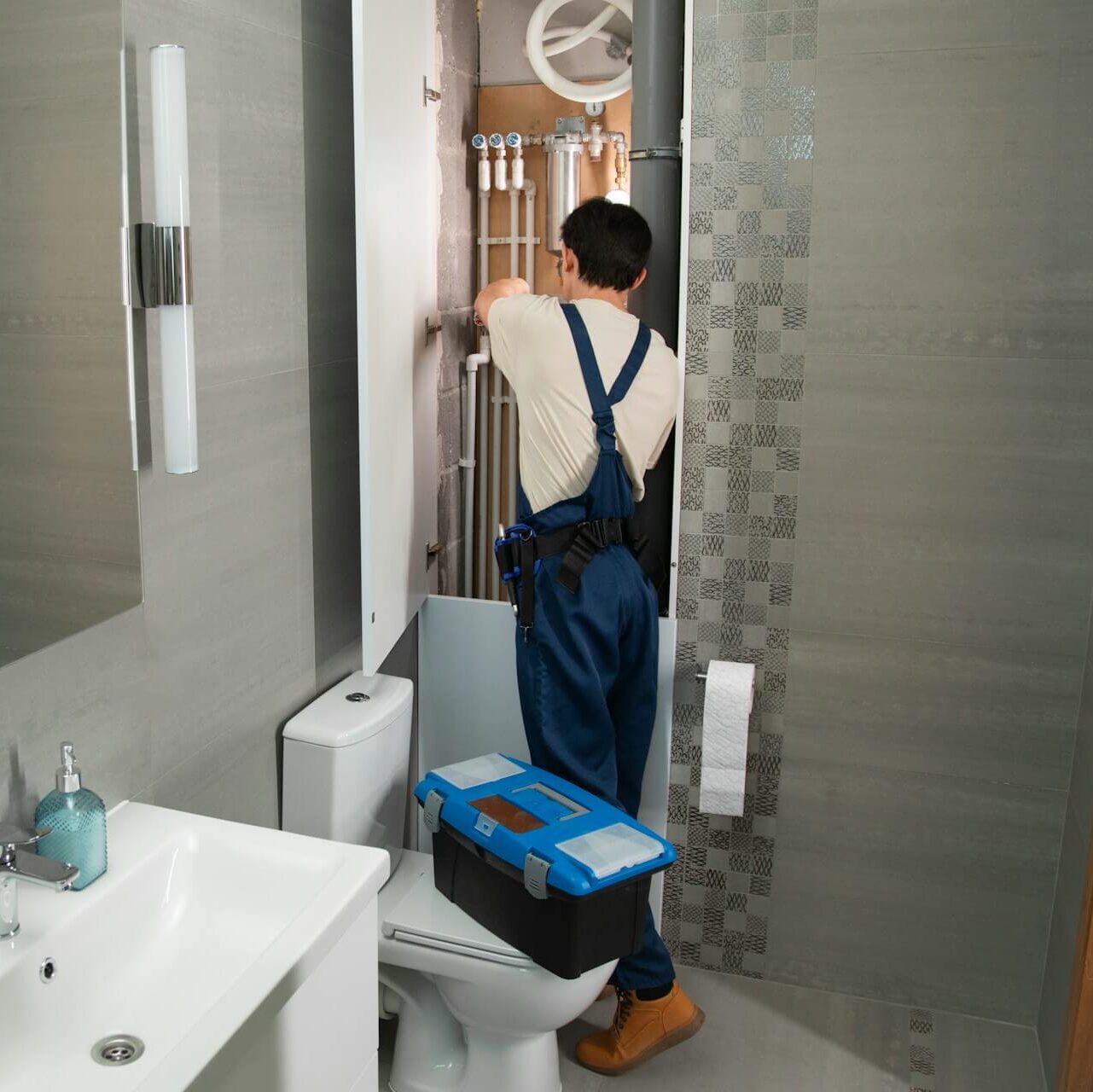 Rörmokare som fixar rören i badrummet.