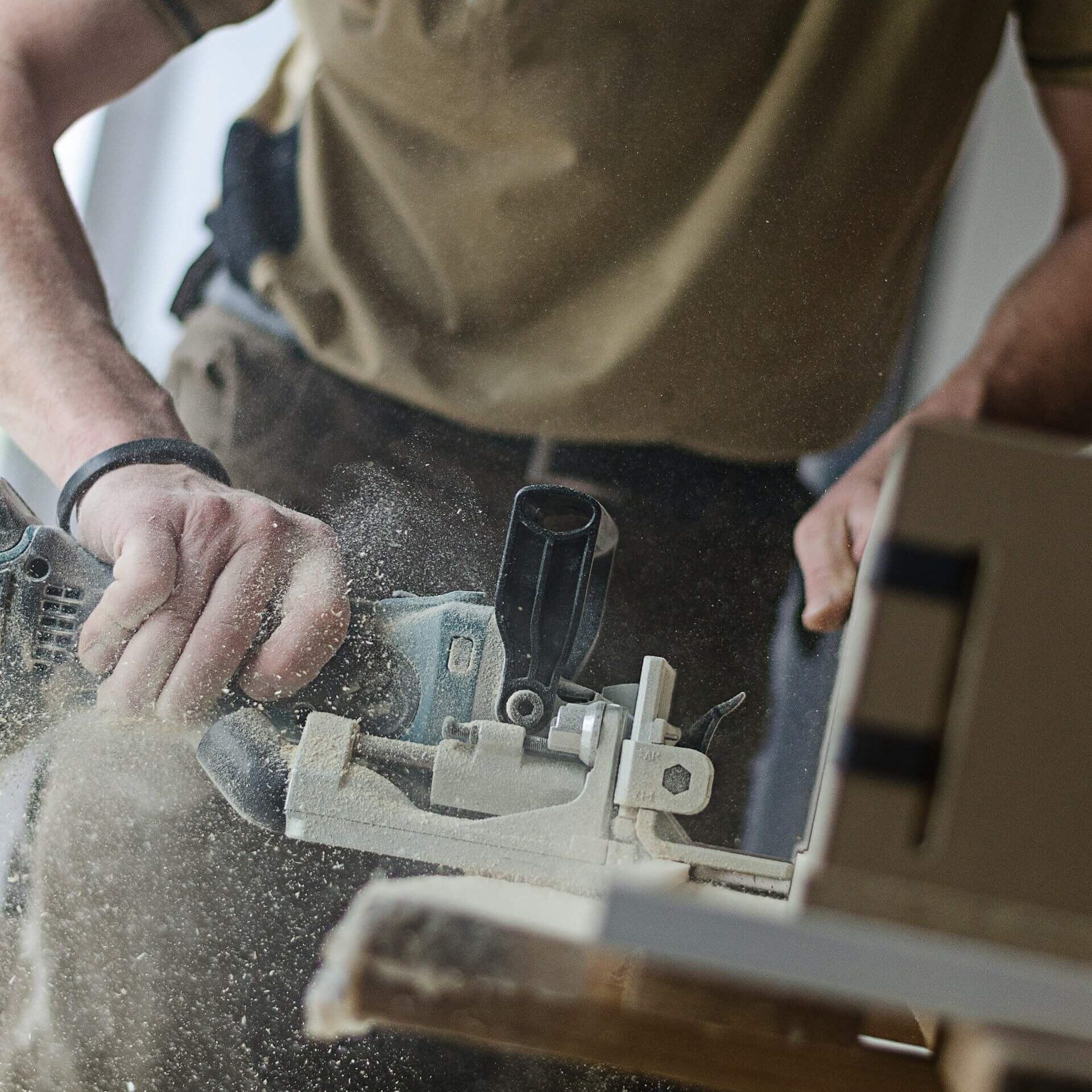 Snickare som sågar i trä.