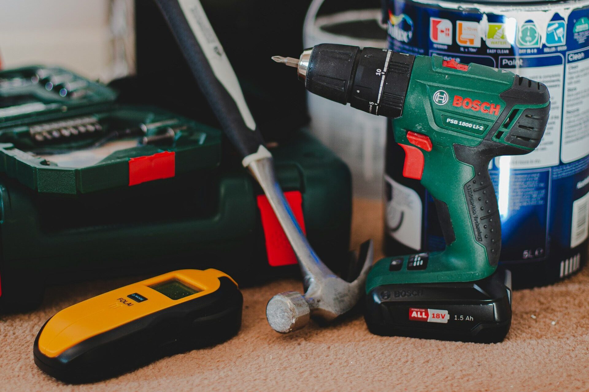 En hantverkares verktyg; borr, hammare och färgburk.